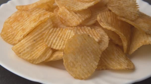 Pommes de terre chips fond macro jaune. Malsaine malbouffe gros plan tournant. — Video
