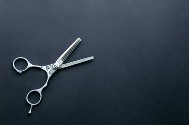 Paslanmaz çelik inceltici saç makasıyla siyah desenli arka plan üzerinde fotokopi alanı.