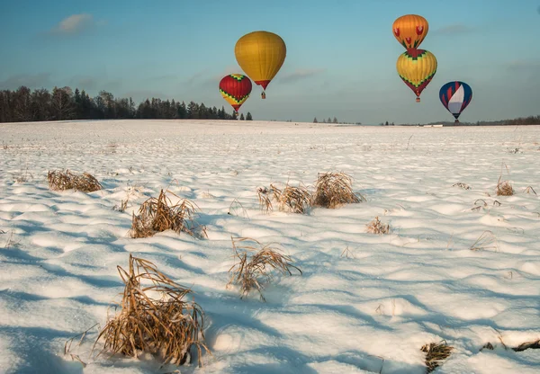 Воздушные шары над снежным полем — стоковое фото