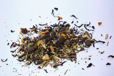 Beyaz arka planda sağlıklı otlar, çay ve kurutulmuş meyvelerle karıştırılıyor. Seçici odak