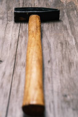 Eski bir tahtanın üzerinde tahta saplı çekiç. Yakın plan. Seçici odaklanma. Harfler ve tasarım için boşluk