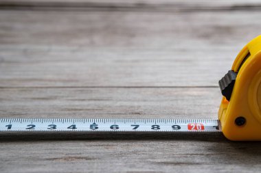 Ölçüm bandı, bulanık ahşap bir arka planla 21 cm 'ye kadar uzanıyor. Yakın plan. Seçici odak.