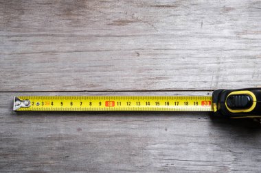 Ölçüm bandı, tahta arka planda 21 cm gerilmiş. Yakın plan. Seçici odak.