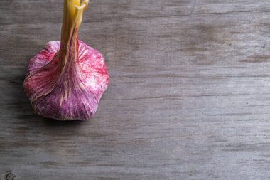 Bulanık ahşap arka planda sarımsak. Seçici odaklanma. Harfler ve tasarım için boşluk.