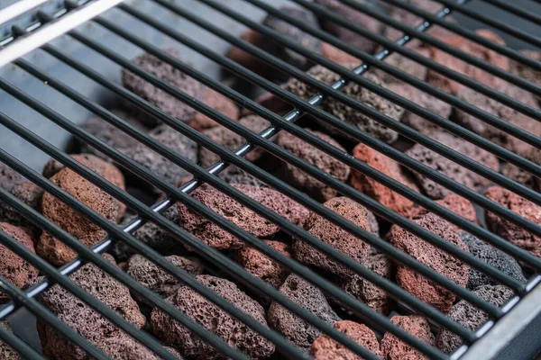 Barbekü ızgarası ve lav taşları parçası. Seçici odaklanma. Harfler ve tasarım için boşluk