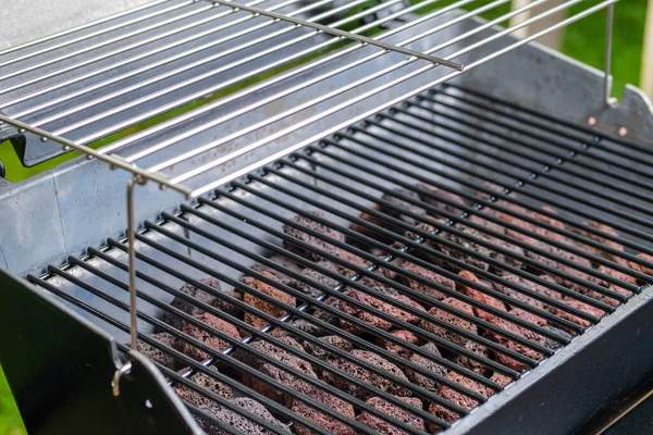 Gaz barbeküsünün bir parçası lav taşlarıyla ızgara yapıyor. Seçici odak.