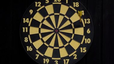 Üç kırmızı ve bir sarı dartı dart tahtasına at. Yakın plan. Seçici odak.