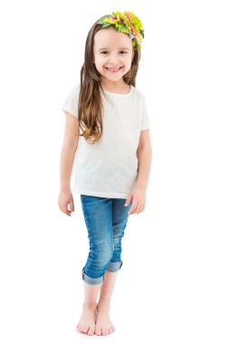 Bir çiçek headdress içinde yalınayak kız beyaz t-shirt ve jeans komik çocuk gülüyor