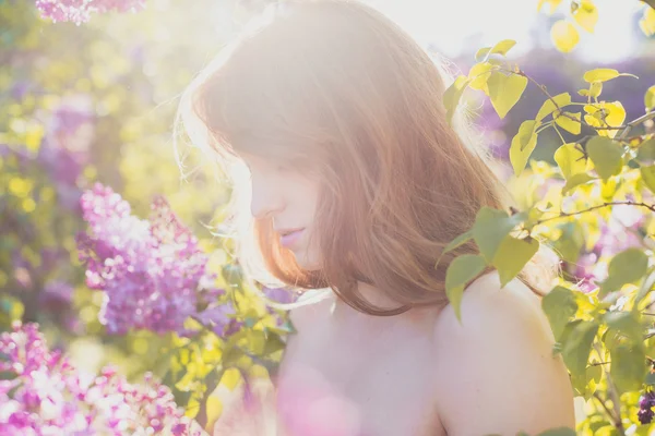 春の花の咲く庭に愛らしい赤い髪の少女. — ストック写真