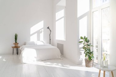 Beyaz ve şık, güneşli bir yatak odası. Tahta masada duran kaktüs ve diğer tarafta siyah lamba. Boş beyaz kopya alanı minimalist kırsal ya da İskandinav tarzı. Yatay olarak. Günaydın.