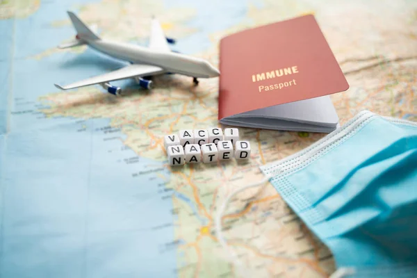 travel planning with immune passport. Vaccinated travelers. Pandemic restriction. Table with map, face mask, plane and international certificate of vaccination. new safety rules. horizontal photo