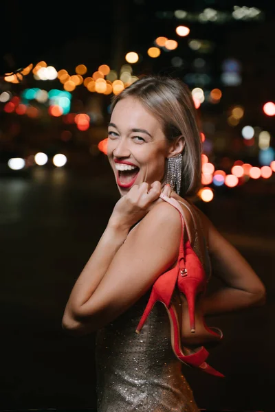 Aktiv Glad Skrattande Blond Kvinna Tittar Kameran Håller Röda Skor — Stockfoto