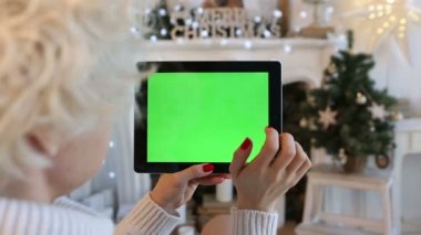 ipad yeşil ekran tutan bir kadın