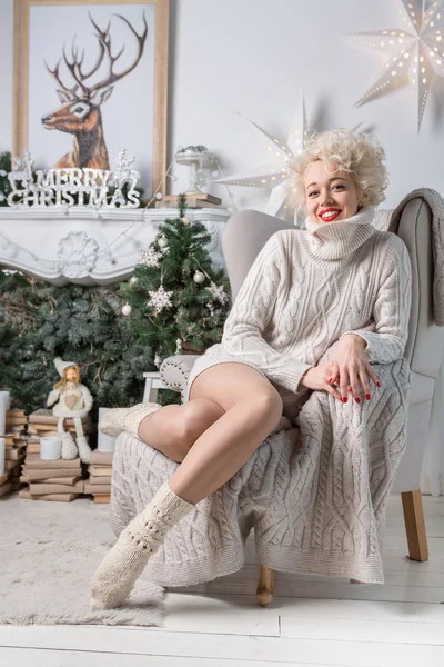 Felice ragazza magra seduta in elegante sedia confortevole beige. Il nuovo anno — Foto Stock