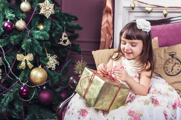 Маленькая девочка в стильном платье и подарки на Новый год — стоковое фото
