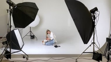  Aşk ve Hayran Hayvan Sahibi 'nin video görüntüleri. Sarışın kadın fotoğrafçı ve köpek Jack Russell Terrier beyaz siklonamayla mutlu fotoğraf stüdyosuna sarılıyorlar. Köpek öpüyor ve kuyruğunu sallıyor. Mutlu an
