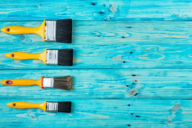 Mavi bir ahşap zemin üzerine sarı fırça