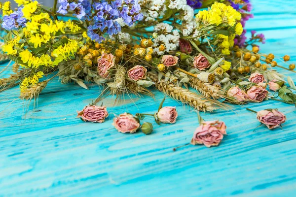 Hermosas flores silvestres yacen en una mesa de textura azul . —  Fotos de Stock