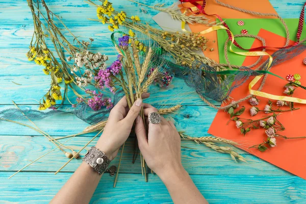 Vrouw handen met een boeket gedroogde bloemen — Stockfoto