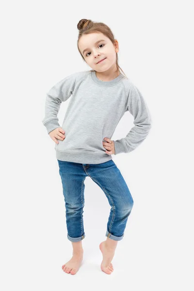 Fille enfant pieds nus en jeans et un pull gris — Photo