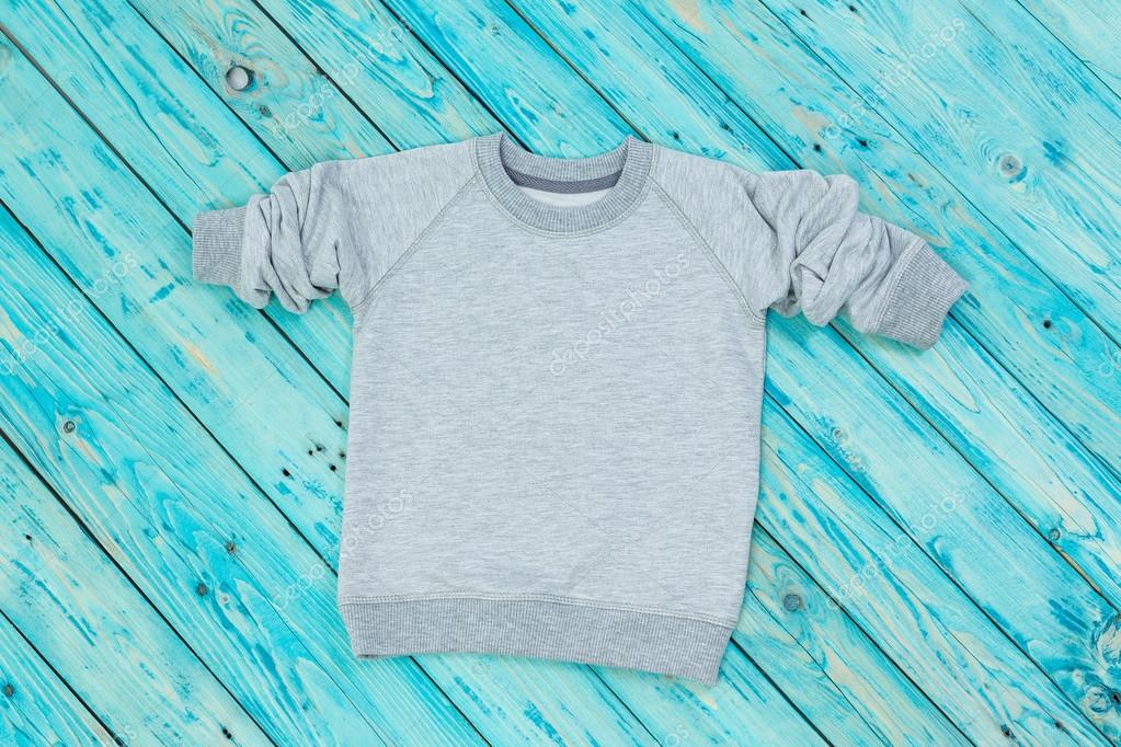 Children's sweater on a wooden rustic blue background. Collection boy and girl clothes without print free space for your image logo.Top view. Other clothing for children and adults in my portfolio