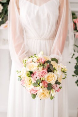 Düğün buketi gelinin elinde. Çiçekli beyaz elbiseli gelin..