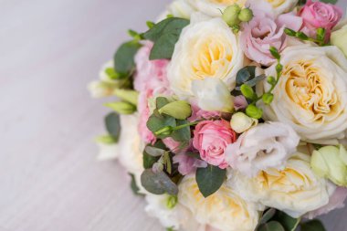 Gri arka planda güzel bir buketin yakın çekimi. Yumuşak pembe güller ve krema, sarı