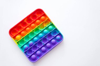 Stres önleyici oyuncağı patlat. Gökkuşağı duyusal kıpırdaması beyaz arka planda izole edilmiş. Yeni moda silikon oyuncak.