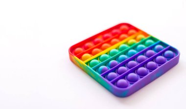 Close-up of pop it on a white background. Rainbow anti-stress toy. Selective Focus