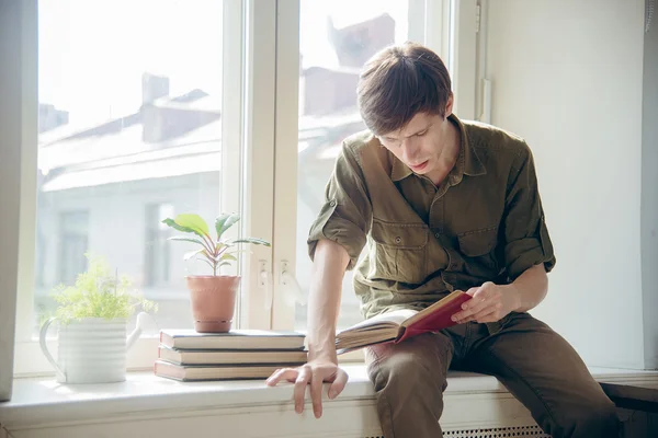 Концентрированный серьезный молодой человек читать книги — стоковое фото