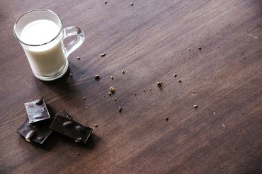 Tohumlar, çikolata ve süt masada fincan ile ekmek.