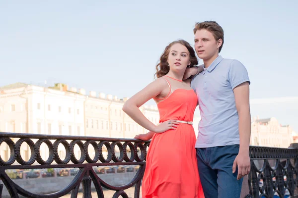 Young man and woman stand together at the city embankment confidently looking forward — Stock Photo, Image