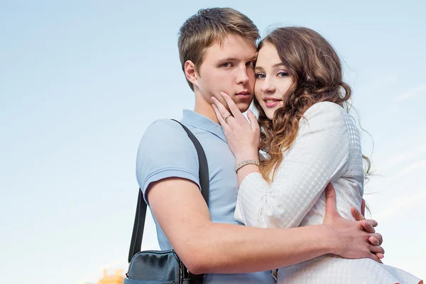 Handsome young woman embrace her sad and serious boyfriend posing. — Stock Photo, Image