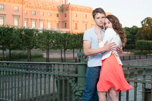 Jovem casal bonito abraçando na ponte perto do palácio histórico . — Fotografia de Stock
