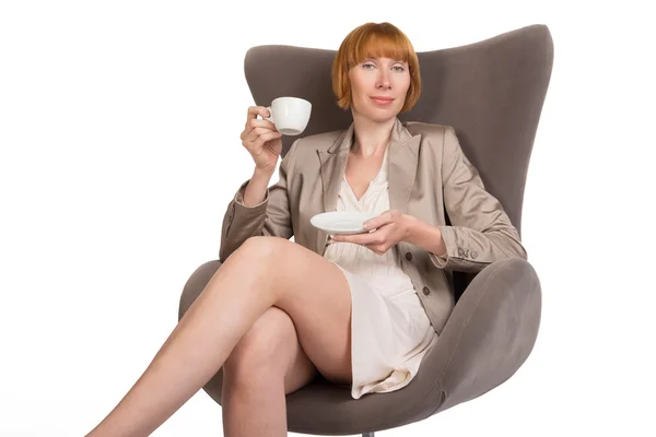 Jovencita en estilo de oficina sentada en silla moderna con una taza de café — Foto de Stock