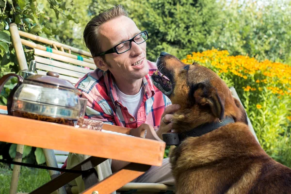 Man and his dog rest in the garden — Stock Photo, Image