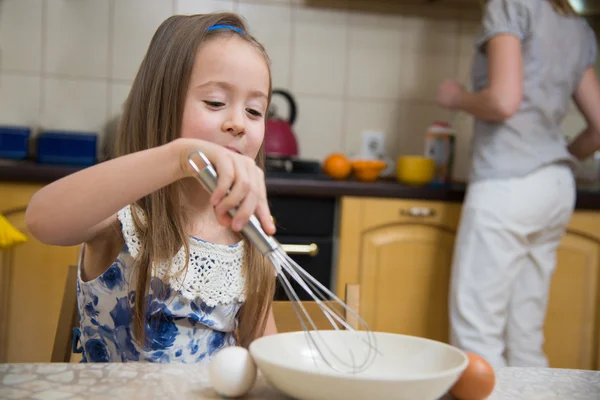 Malá dívka bude porazit těsto na palačinky — Stock fotografie