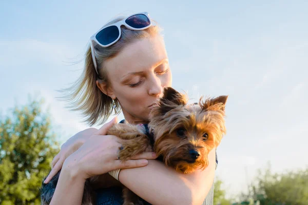 Beautiful young happy woman with blonde hair holding small dog — Stock Photo, Image