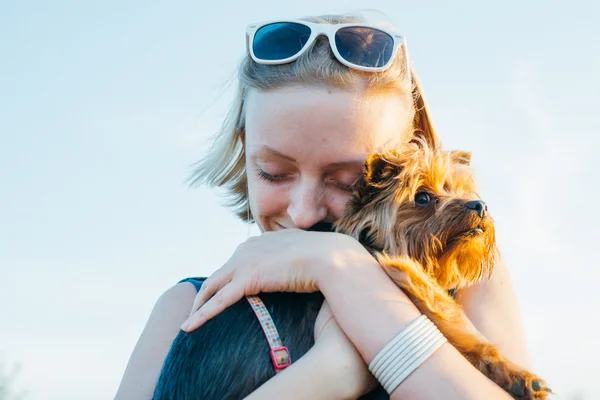 Belle jeune femme heureuse avec des cheveux blonds tenant petit chien — Photo