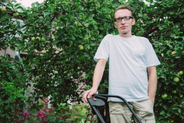 Çim biçme makinesi olan adam.