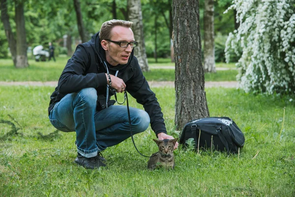 Mens de kat buiten spelen — Stockfoto