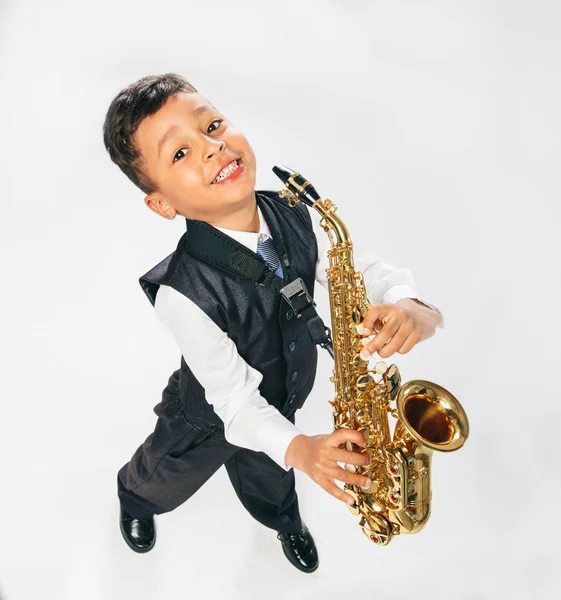 Six years old boy plays saxophone at studio — Stock Photo, Image