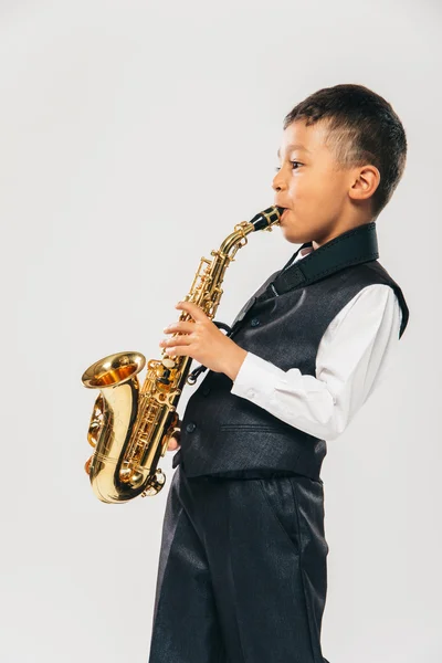 Six years old boy plays saxophone at studio — Stock Photo, Image