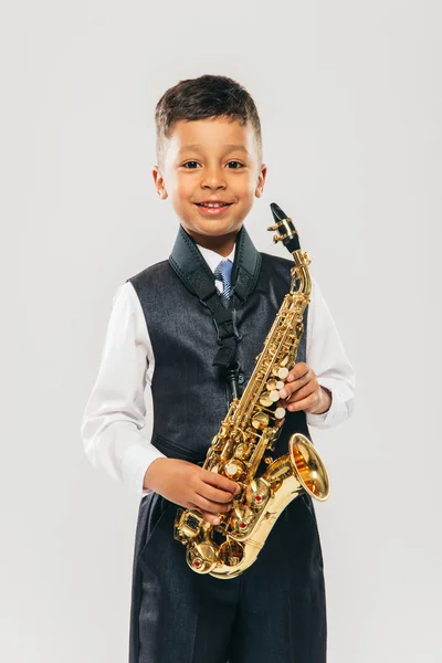 Seis anos de idade menino toca saxofone no estúdio — Fotografia de Stock