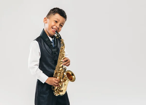 Six years old boy plays saxophone at studio — Stock Photo, Image