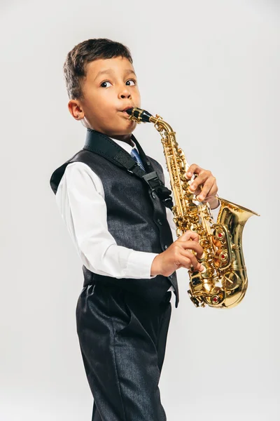 Six years old boy plays saxophone at studio — Stock Photo, Image