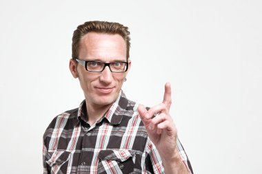 Onun parmağı yakışıklı adam gözlük ve ekose gömlek çıkarmak. 