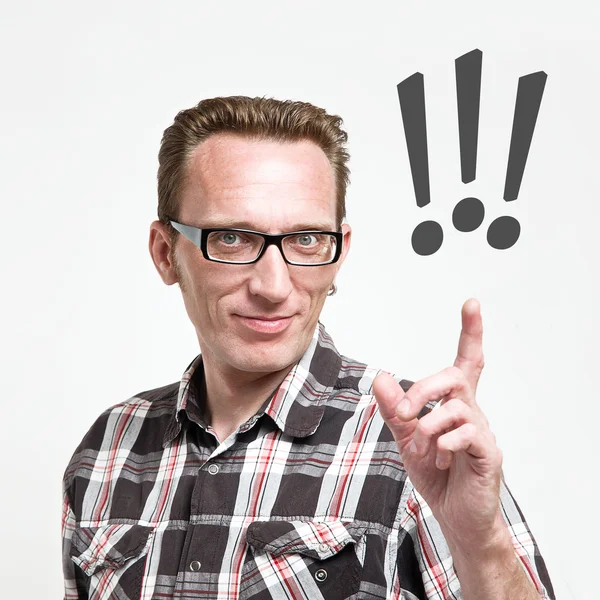 Schöner Mann mit Brille und Schottenhemd reckt Zeigefinger zum Ausrufezeichen. — Stockfoto