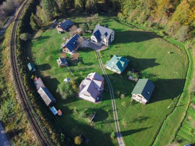 Dağın eteğindeki yeşil çimenlikteki evler demiryolu raylarının yanında. Köyün en iyi manzarası.