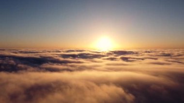 Hızlandırılmış kayıt, sabahın erken saatlerinde güneş ufukta doğduğunda bulutların üzerinde hızlandırılmış bir uçuş..